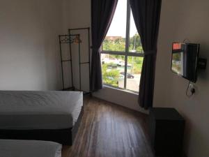 a room with two beds and a large window at BENUTHOMESTAY in Kampong Parit Tengah