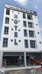 a large white building with a clock on it at Weiss Hotels Kepong Baru in Kuala Lumpur