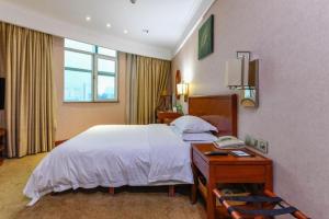 una camera d'albergo con letto e telefono di GreenTree Inn GuangDong DongGuan HouJie Business Hotel a Dongguan Altre 245 foto
