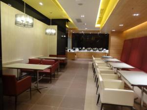 a restaurant with tables and chairs and a large screen at Jinjiang Inn Tianjin Changjiang Avenue in Tianjin
