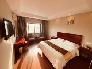 a bedroom with a bed and a desk and a window at GreenTree Inn Jiangsu Huaian Bus Terminal North Station Huaihai North Road Business Hotel in Huai'an