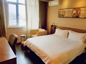 Un pat sau paturi într-o cameră la Jinjiang Inn Select Qingdao West Coast Coach Exhibition Center High-Speed Railway Station +149 fotografii