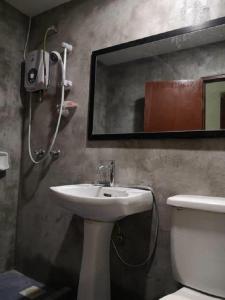 une salle de bain avec un lavabo, des toilettes et un miroir dans l'établissement Hotel Sarina, à Mukah