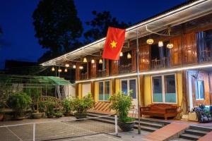 a house with a flag on the side of it at Tien Tour & Homestay in Bản Kin +9 photos