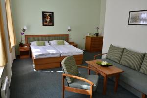 um quarto com uma cama, um sofá e uma mesa em Castle Residence Praha em Praga