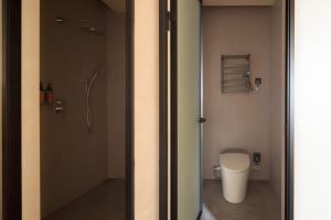 a bathroom with a shower and a toilet in it at Mengyuan Bian Seaview Private Hot Spring Vacation Courtyard (Jiaochangwei Beach Branch) in Dapeng +132 photos
