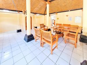 a dining room with wooden chairs and a table at Hotel Family Syariah 1 Parangtritis RedPartner in Parangtritis