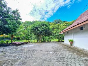 a stone driveway in front of a building at Hotel Family Syariah 1 Parangtritis RedPartner in Parangtritis