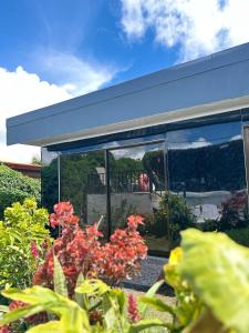 a building with glass windows and flowers in front of it at Residencia Esmeralda in Agua Buena