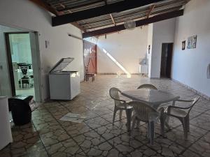 a room with a table and chairs and a piano at Peruíbe lazer in Peruíbe