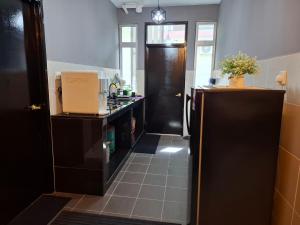 a kitchen with a black door and a tile floor at Nohana Homestay, Alor Gajah in Kampong Jelatang