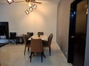 a dining room with a white table and chairs at Nohana Homestay, Alor Gajah in Kampong Jelatang