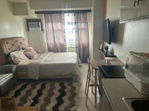 een kleine kamer met een bed en een raam bij Cozy and Affordable Studio Unit in Cebu City