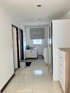 a white kitchen with a sink and a refrigerator at TONY Central Stay in Phuket Town
