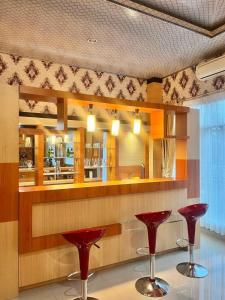 a bar with two red stools in a room at Wisma Jannatun Naim Lampung in Lampung