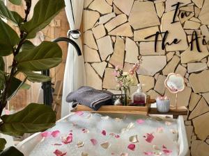 a bathroom with a bath tub with a stone wall at Cabin In The Air in Ấp Ða Lợi
