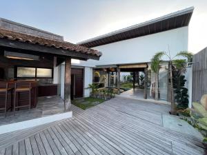 Tanah Lot Dreams Complex Villas By GUMA Hospitality في تاناه لوت: اطلالة خارجية على منزل وسطح خشبي