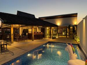 Tanah Lot Dreams Complex Villas By GUMA Hospitality في تاناه لوت: فيلا مع مسبح ومنزل