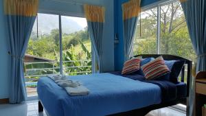 a bedroom with a blue bed with a large window at Dr. House in Campson