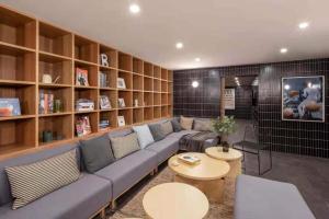 a living room with a couch and tables and shelves at base-WENDING Service Apartment-Shanghai Xujiahui Location in Shanghai