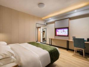 a hotel room with a large bed and a tv at GreenTree Inn Express Fujian Ningde Ningchuan Road Qinghua Building in Ningde