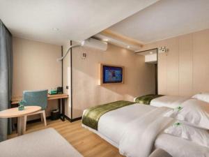 a hotel room with two beds and a table at GreenTree Inn Express Fujian Ningde Ningchuan Road Qinghua Building in Ningde +111 photos