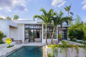 a house with a swimming pool and palm trees at East Bali Volcano View Resort & Spa - Adults Only Area in Candidasa