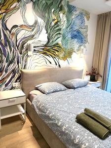 - une chambre avec un lit orné d'une fresque murale dans l'établissement Malūno Vilos 1M7, à Palanga 18 autres photos