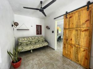 a living room with a couch and a wooden door at Dicha Perfecta Telchac in Telchac Puerto
