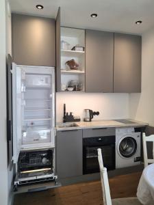 a kitchen with an open refrigerator and a sink at Villa Manna - Charming Flat in a Historic House in Tallinn +12 photos