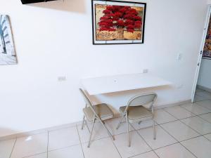 a table and chairs in a room with a painting on the wall at Departamento 22 centrico,cerca de los destinos clave, CAS, Consulado, Centro de Gobierno y Galerías Mall in Hermosillo