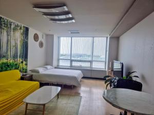 a room with two beds and a table and a couch at Cozy - Good Vibes Studio in Incheon