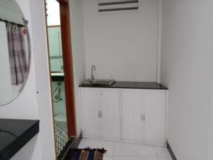a white kitchen with a sink and a mirror at Unique Hotel in Phnom Penh +66 photos