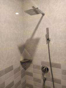 a shower stall with a shower head and a light at Meatophum Samnang in Battambang