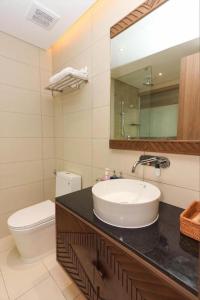 a bathroom with a sink and a toilet and a mirror at Victor Group - Sam Sam Phu Yen Condotel in Phước Hậu