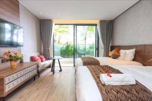 a hotel room with two beds and a large window at Victor Group - Sam Sam Phu Yen Condotel in Phước Hậu +21 photos