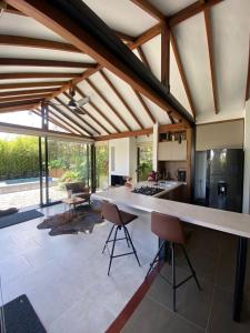 an open kitchen with a large white counter and chairs at Cabaña Lembos Jacuzzi con vista al cielo in Pereira