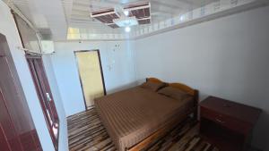 LagudriNias Frank Accomodation的一间带床和桌子的小卧室