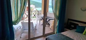 a bedroom with a bed and a balcony with a table and chairs at Stunning Sea View Studio in Andalucia Beach Hotel by Flat Mаnager in Elenite