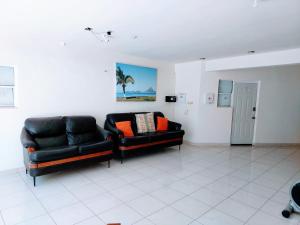 una sala de estar con 2 sofás de cuero negro en Loft 25 excelente y comodo, cerca del vado del rio, consulado,CAS, galerias mall , cama queen , cocineta, en Hermosillo