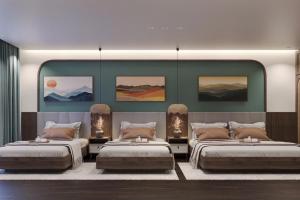 two beds in a room with paintings on the wall at Sunrise Mountain View Resort in Vang Vieng +41 photos