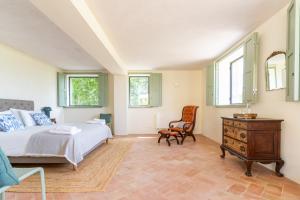 ein Schlafzimmer mit einem Bett und einem Stuhl und Fenstern in der Unterkunft Casa da Raposeira Douro Valley in Armamar + 47 Fotos