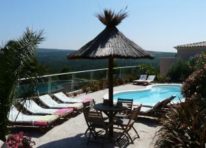 eine Terrasse mit Stühlen und Sonnenschirm und ein Pool in der Unterkunft Grand Studio "Figuières" - Domaine Ciel et Mer in Ensuès-la-Redonne + 10 Fotos