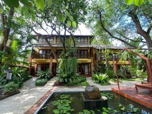 una casa con un estanque koi delante de ella en Baan Talay Dao Resort, en Hua Hin