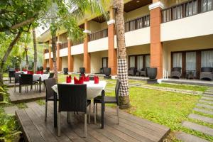 a restaurant with tables and chairs in front of a building at The Arnawa Hotel in Pangandaran