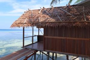 a hut with a straw roof on the beach at Kasumasa Homestay in Fambemuk