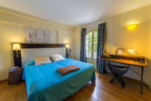 a bedroom with a blue bed and a desk at Le Juliette Dodu in Saint-Denis