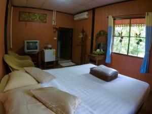 Una cama blanca grande en una habitación con televisión. en Chiangsan Goldenland Resort, en Chiang Saen 192 fotos más