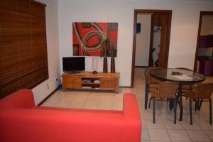 a living room with a red couch and a table at Wildsights Beach Units in Denham