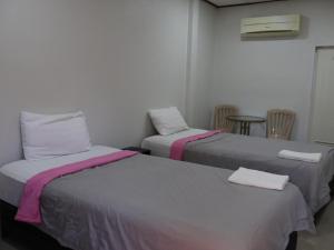 a room with two beds and a table and chairs at Suanlamyai Resort in Loei